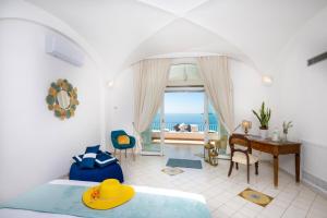 波西塔诺YourHome - Villa Aldo Marino的一间卧室设有一张床和一张书桌,享有海景