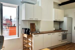 格勒诺布尔The top perch #ET的厨房配有白色橱柜和窗户。
