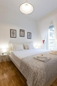 萨格勒布Vedrana-Free garage的白色的卧室设有一张白色大床和一个窗户。