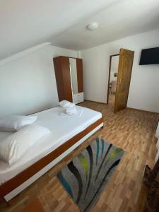 图兹拉Casuta Morena的卧室设有一张白色大床和木地板
