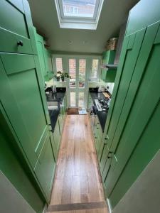 伦敦Beautiful & Cosy 2BD House - Southwark的铺有木地板的厨房配有绿色橱柜