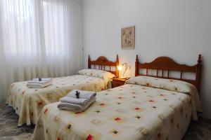 洛尔卡Casa de invitados tradicional con piscina en la huerta de Lorca的一间卧室配有三张床和毛巾