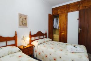 洛尔卡Casa de invitados tradicional con piscina en la huerta de Lorca的一间卧室配有两张床和一张带台灯的桌子