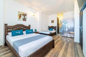 卡利Santiago DC Hotel的一间卧室配有一张带蓝色枕头的大床