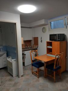 圣托斯特凡诺港Residence Sole Dell'Argentario的带桌子和两把椅子的厨房以及带水槽的厨房