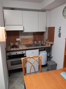 圣托斯特凡诺港Residence Sole Dell'Argentario的厨房配有白色橱柜、水槽和桌子