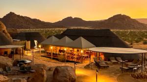 KhorixasTwyfelfontein Adventure Camp的日落时分在沙漠中的一个狩猎帐篷