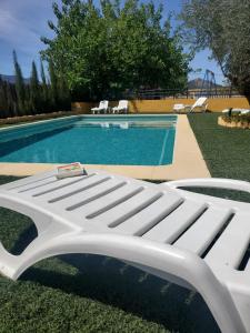 贝莱斯-鲁维奥Casa Los Bartolos的游泳池旁的白色长凳