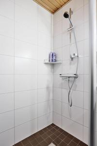 坦佩雷Rauhallinen kolmio omalla saunalla Tampereen keskustassa的白色瓷砖浴室内的淋浴