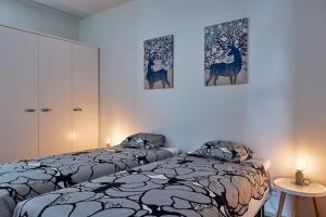 坦佩雷Rauhallinen kolmio omalla saunalla Tampereen keskustassa的一间卧室设有两张床,墙上挂有绘画作品