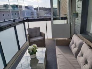 坦佩雷Rauhallinen kolmio omalla saunalla Tampereen keskustassa的阳台配有沙发、椅子和玻璃桌