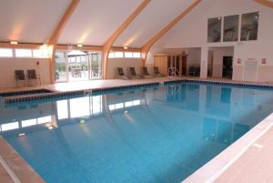 大圣科勒姆Skylark sleeps 8 private Hot Tub & Dogs welcome Nr Padstow, Resort Pool Bar & Watersports的大楼内一个蓝色的大型游泳池