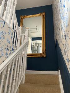 金塞尔Summer Cottage in Kinsale的一个带镜子和蓝色墙壁的楼梯