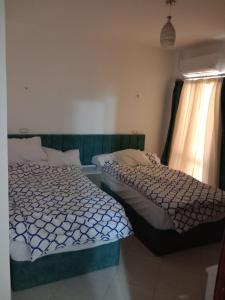 沙姆沙伊赫2 Bedroom Apartment with pool view的一间卧室设有两张床和窗户。