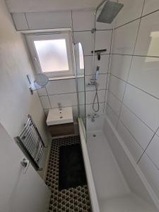 伦敦Cozy room - Only room的带浴缸、水槽和窗户的浴室