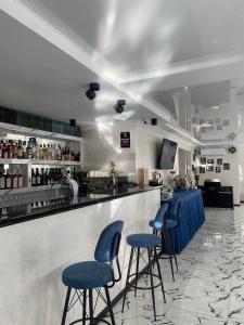 巴统Hotel Sonata的餐厅内带蓝色酒吧凳的酒吧