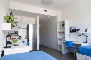 桑坦德Apartamentos Turísticos UNEATLANTICO的客房设有一张床、一张书桌和一间厨房