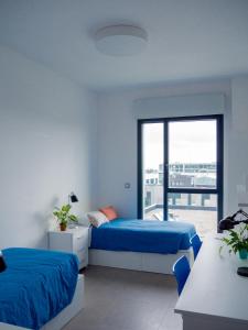 桑坦德Apartamentos Turísticos UNEATLANTICO的一间卧室设有两张床和大窗户