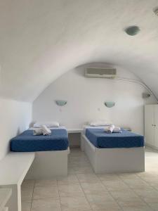佩里萨M.G. Hotel Studio & Apts的白色客房的两张床,配有蓝色的床单