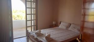 埃雷特里亚Seaview Miloi的一间卧室配有一张带白色床单的床和一扇窗户。
