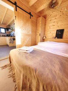 东卡佩勒NEW! Tiny House Lantliv Oostkapelle, bij de boer的木制客房内的一间卧室,配有一张床