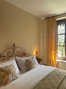 Ozzano Monferrato毗邻四季住宿加早餐旅馆的卧室配有带枕头的白色床和窗户。