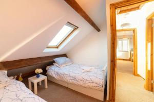 伯恩利Oak Tree Cottage - Pendle - Forest of Bowland的阁楼卧室设有两张床和窗户。