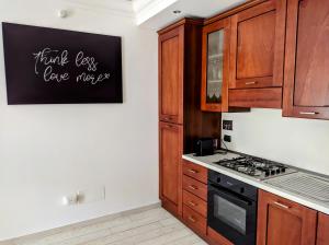 罗马La casetta gialla的厨房配有木制橱柜和黑炉灶烤箱。