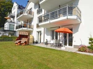 奥斯赛拜-塞林Residenz Falkenberg - Apt. 03的一座带橙色伞和草坪的房子