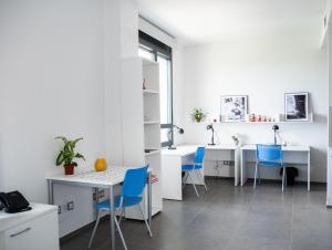 桑坦德Apartamentos Turísticos UNEATLANTICO的厨房配有白色的柜台和蓝色的椅子