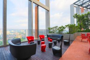 吉隆坡NEW # Midvalley MILLERZ SQUARE KL KLCC - Netflix n WIFI by GOMAIN的大楼内的阳台配有沙发和红色椅子