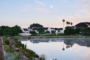 斯泰伦博斯The Hazendal Hotel in the Stellenbosch Winelands by NEWMARK的享有房屋和湖泊的景致。