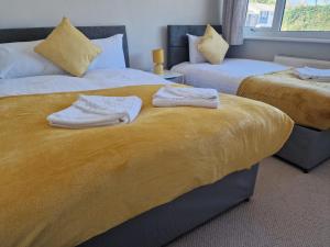 利兹4 beds with links to motorways的一间卧室配有两张带毛巾的床