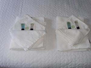 巴斯Brocks的床上的2条白色毛巾,配有牙刷和牙膏