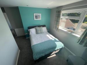 滕比Pen Mar Guest House B&B的一间小卧室,配有一张蓝色墙壁的床