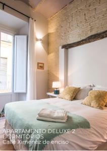 塞维利亚博提科公寓的一间卧室设有一张带砖墙的大床