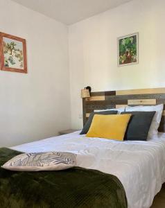 比斯卡罗斯Appart-dans Résidence de vacances au coeur du Golf-Le domaine de Gascogne的卧室配有一张带黄色枕头的大型白色床。