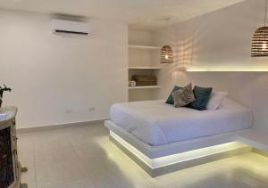 伯里塔卡Hotel La Finca Buritaca by DOT Premium的白色卧室配有带枕头的床