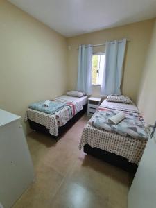 佩尼亚Ipê Eco Village的一间卧室设有两张床和窗户。