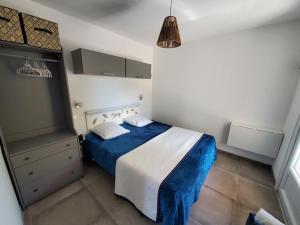 格雷乌莱班La casa Elisa Gîte T2 indépendant的一间位于客房内的卧室,配有蓝色和白色的床