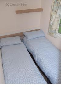 爱丁堡3 Bedroom at Seton Sands Caravan Hire的两张睡床彼此相邻,位于一个房间里
