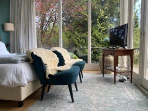阿纳姆Appartement Osso Arnhem的卧室配有一张床和两把椅子,位于窗户前