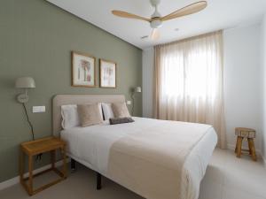 大加那利岛拉斯帕尔马斯Royal Suites的卧室配有白色的床和吊扇