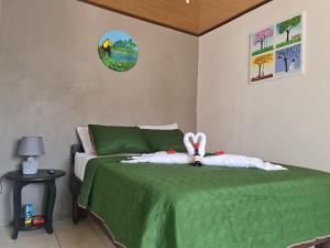 福尔图纳Cabinas Guayabón #4 La Fortuna Volcán Arenal的一间卧室,配有一张绿床,上面有一条小 ⁇ 