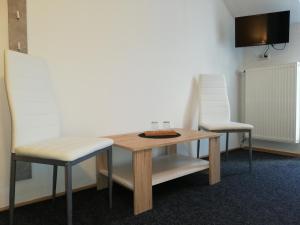 巴尔代约夫Villa LIKE "garden-grill"的两把椅子和一张木桌以及一张桌子和椅子
