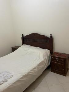 塞拉Holiday house的一张带木制床头板和床头柜的床