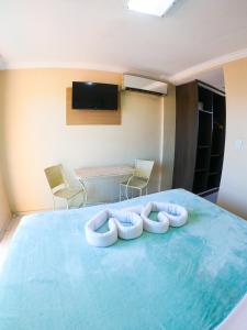 嘎林海斯港Estação do Sol Praia Hotel的一间设有两张枕头的床的客房