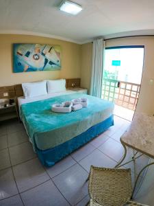嘎林海斯港Estação do Sol Praia Hotel的一间卧室配有一张床,上面有两条毛巾