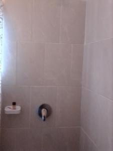卡萨内Sunshinevibe guest house的浴室设有带水龙头的瓷砖淋浴间