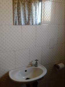 卡萨内Sunshinevibe guest house的白色的浴室设有水槽和窗户。